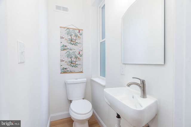 bathroom with toilet, sink, and hardwood / wood-style flooring