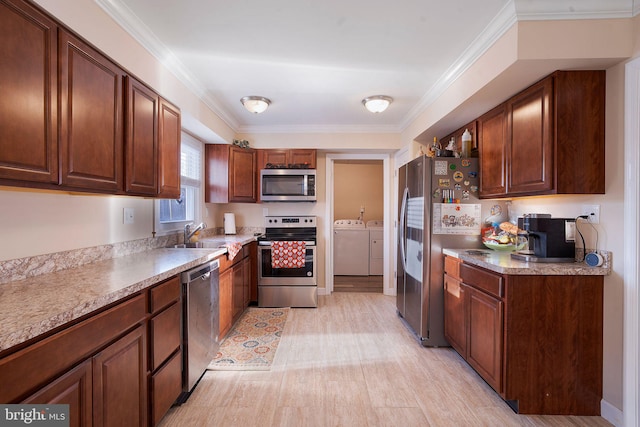 kitchen with appliances with stainless steel finishes, light hardwood / wood-style floors, sink, ornamental molding, and independent washer and dryer