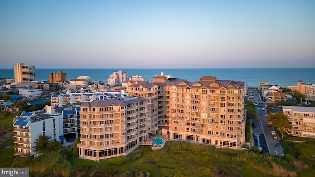 aerial view at dusk featuring a water view