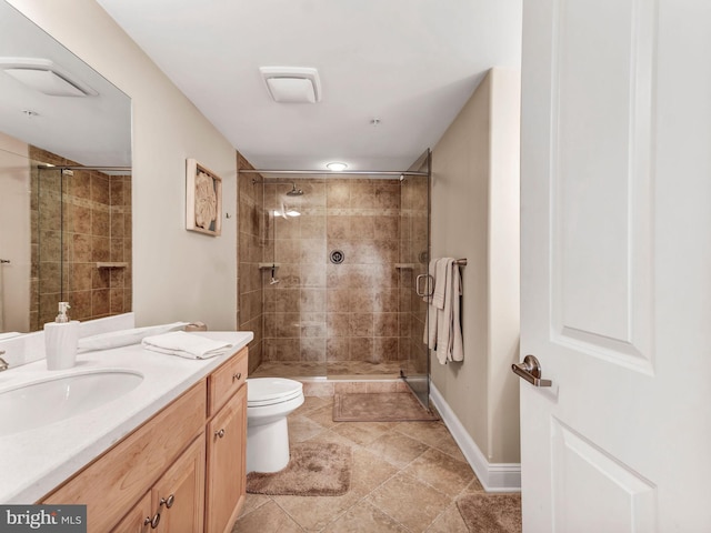 bathroom with tiled shower, vanity, and toilet