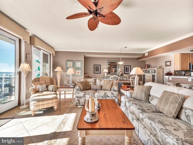 tiled living room with ceiling fan and ornamental molding