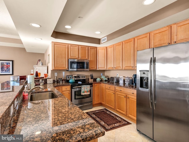 kitchen with appliances with stainless steel finishes, dark stone counters, sink, kitchen peninsula, and light tile patterned floors