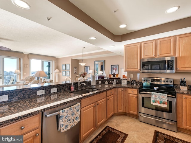 kitchen featuring decorative light fixtures, appliances with stainless steel finishes, sink, and dark stone counters