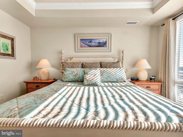 bedroom with a raised ceiling and ornamental molding