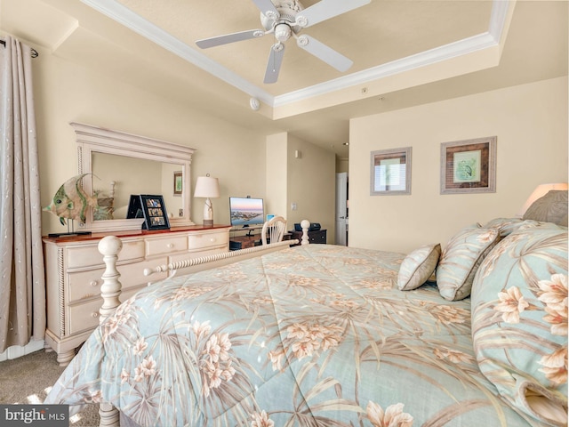 bedroom featuring ceiling fan, crown molding, a tray ceiling, and carpet floors