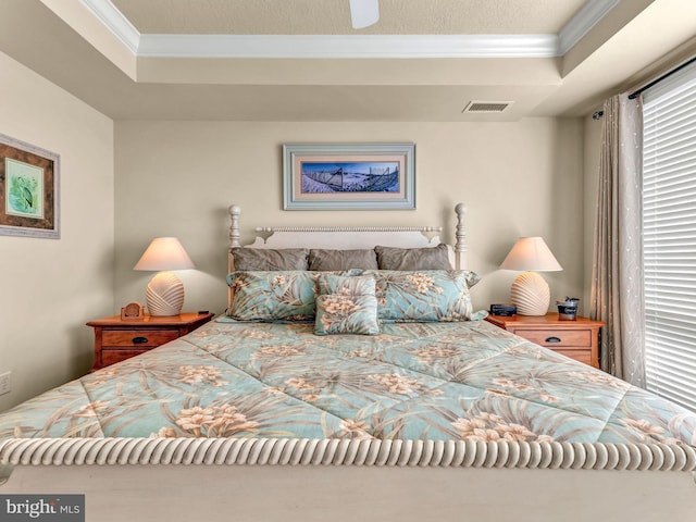 bedroom with crown molding and a raised ceiling