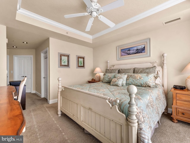 carpeted bedroom with ceiling fan, ornamental molding, and a raised ceiling