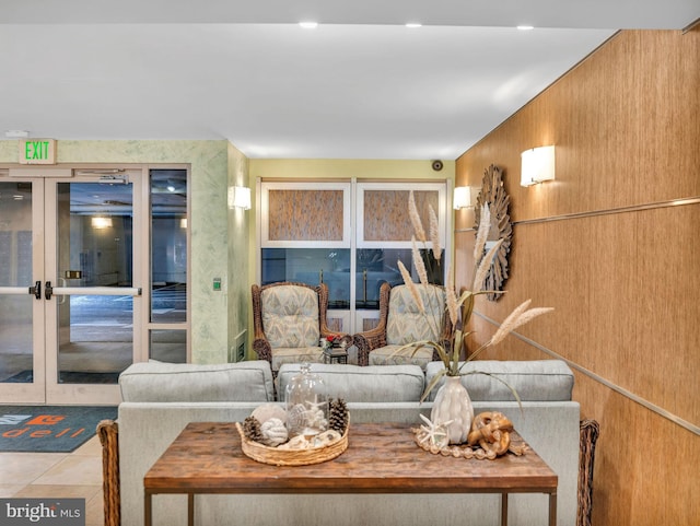 tiled living room featuring lofted ceiling and french doors