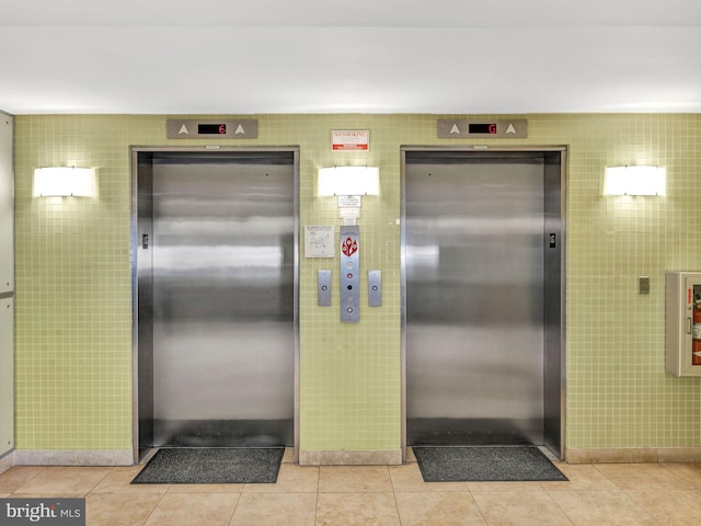 interior space with light tile patterned flooring and elevator