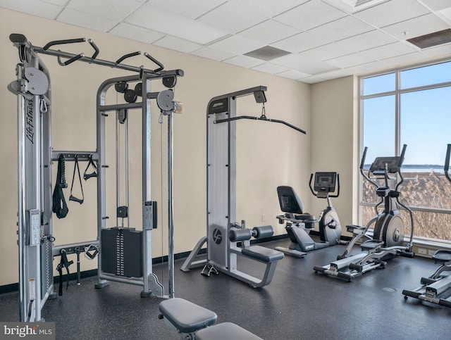 gym with a drop ceiling and expansive windows