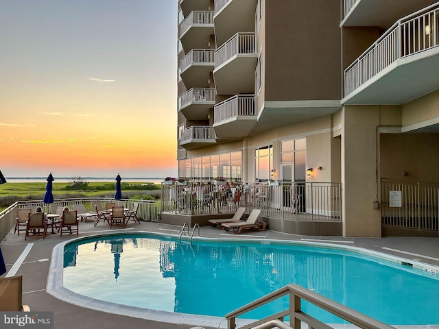 pool at dusk with a patio