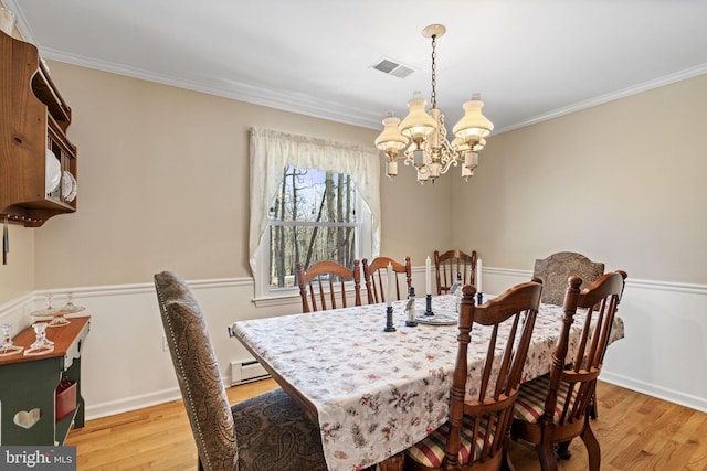 dining room featuring ornamental molding, a chandelier, and light hardwood / wood-style floors