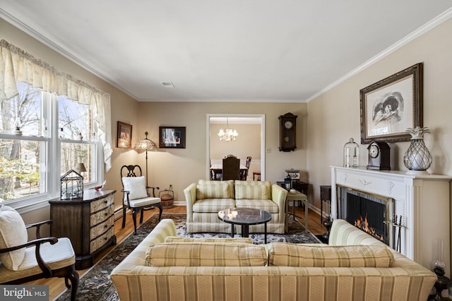 living room with hardwood / wood-style floors, ornamental molding, and a chandelier