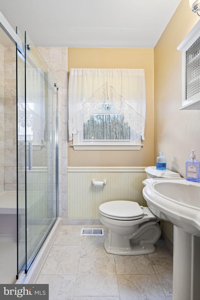 bathroom featuring walk in shower and toilet