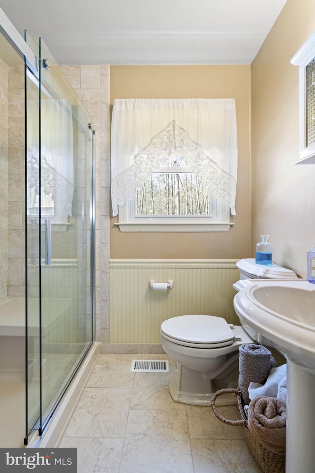 bathroom with an enclosed shower and toilet