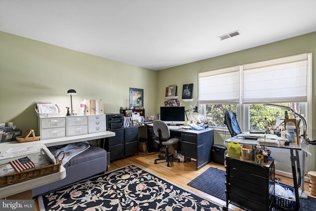 home office with light hardwood / wood-style floors