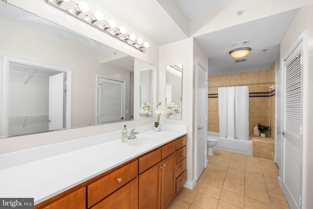 full bathroom featuring shower / bath combo with shower curtain, tile patterned floors, vanity, and toilet