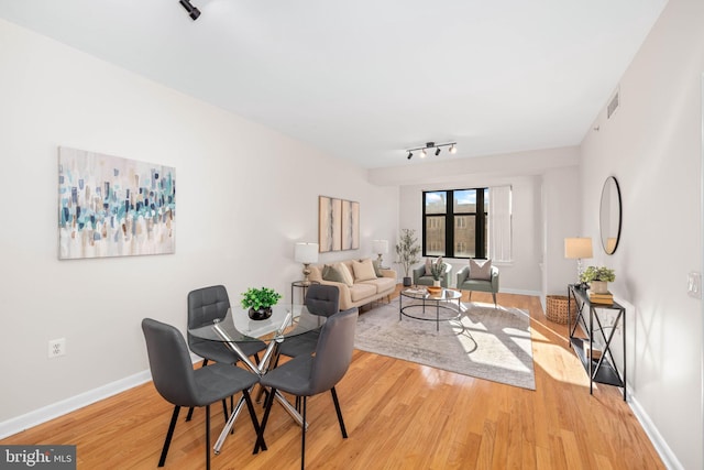 dining space featuring track lighting and hardwood / wood-style floors