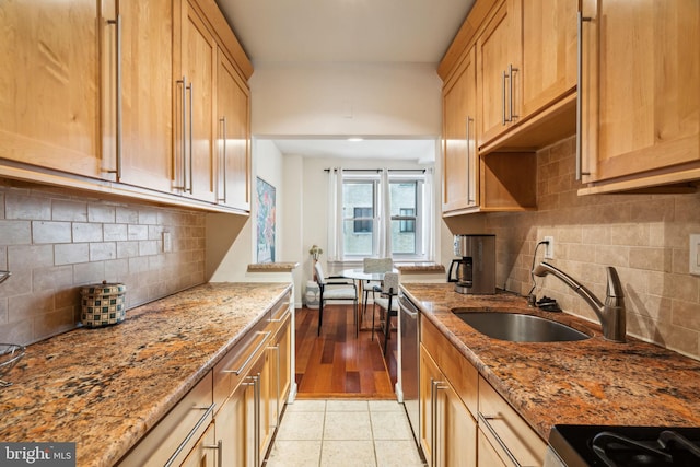 kitchen with light stone countertops, sink, decorative backsplash, and light tile patterned floors