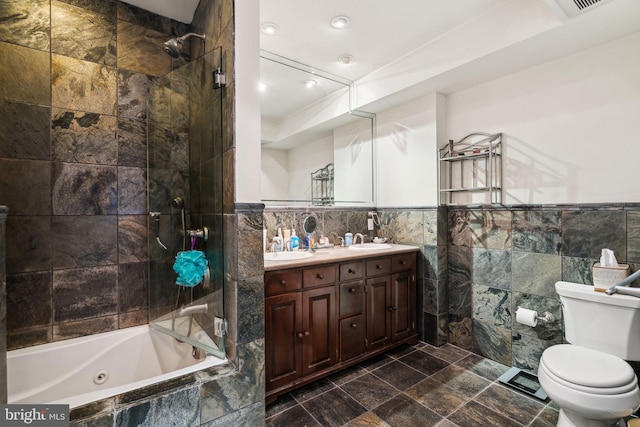 full bathroom featuring tile walls, vanity, toilet, and tiled shower / bath