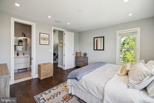 bedroom featuring connected bathroom and dark hardwood / wood-style floors