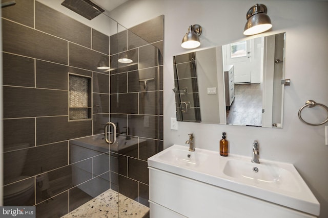 bathroom featuring a shower with door and vanity