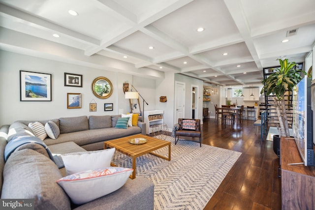 living room featuring dark wood-type flooring, coffered ceiling, and beamed ceiling