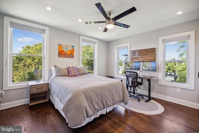 bedroom with ceiling fan, dark hardwood / wood-style flooring, and multiple windows