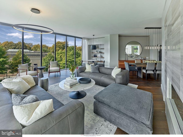 living room with floor to ceiling windows, a notable chandelier, dark hardwood / wood-style flooring, and plenty of natural light