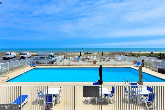 view of pool featuring a water view and a patio area