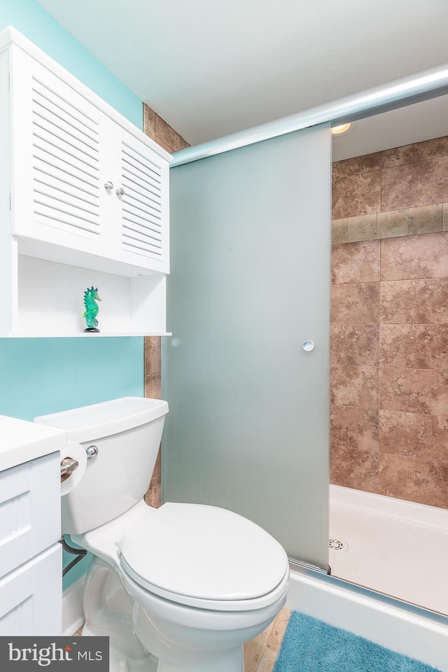 bathroom featuring toilet, an enclosed shower, and vanity