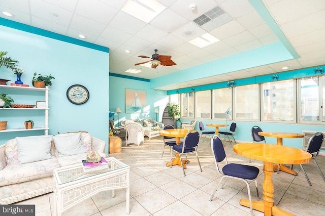 sunroom / solarium with ceiling fan and a drop ceiling