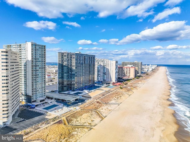 birds eye view of property featuring a water view and a beach view