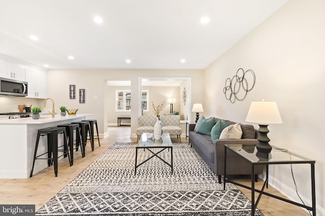 living room with sink and light wood-type flooring