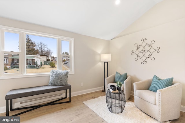 sitting room with light wood-type flooring and vaulted ceiling