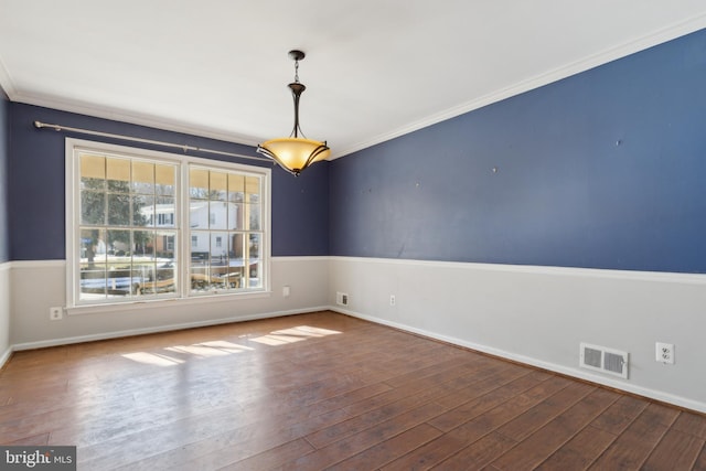 spare room featuring wood-type flooring and ornamental molding