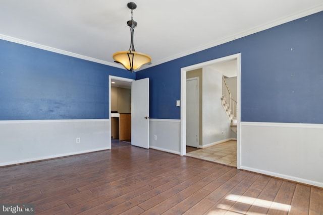 spare room with crown molding and wood-type flooring