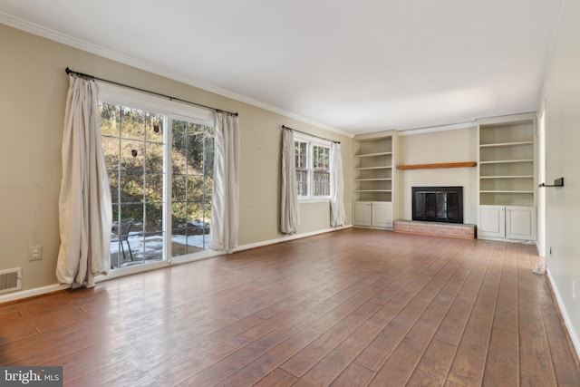 unfurnished living room with hardwood / wood-style flooring, a fireplace, and crown molding