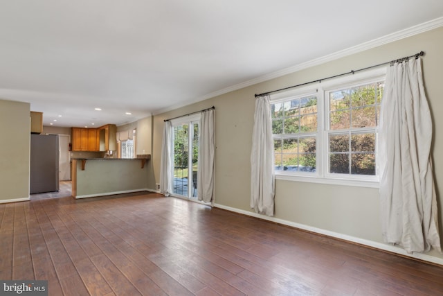 unfurnished living room featuring dark wood-type flooring and crown molding