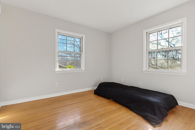 bedroom with multiple windows and light wood-type flooring