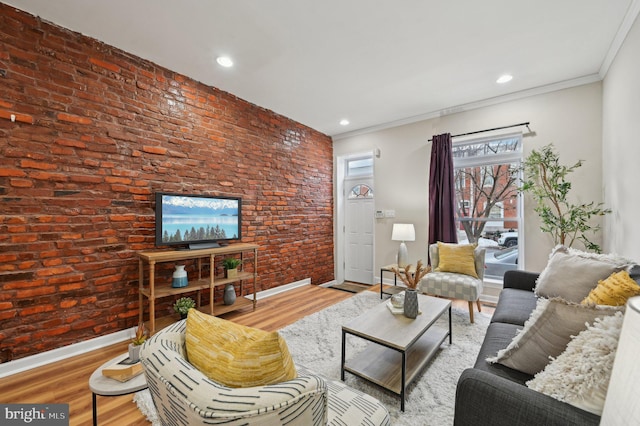 living room with wood-type flooring, brick wall, and ornamental molding