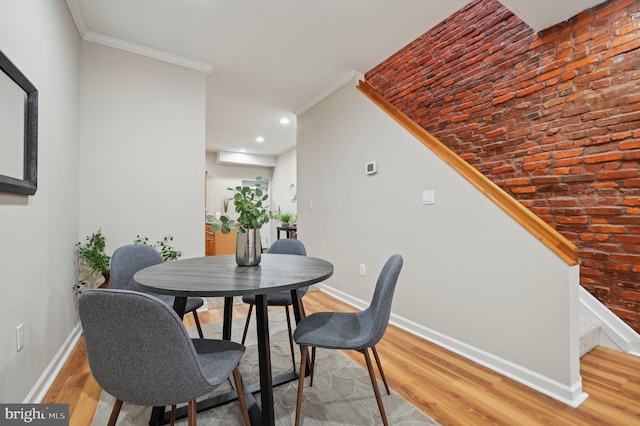 dining space with wood-type flooring and crown molding