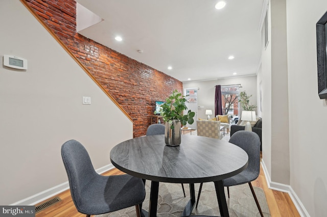 dining space with light wood-type flooring and crown molding