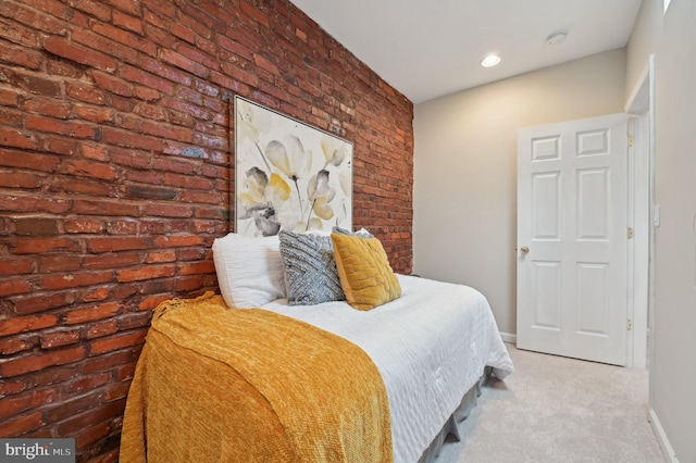 carpeted bedroom featuring brick wall