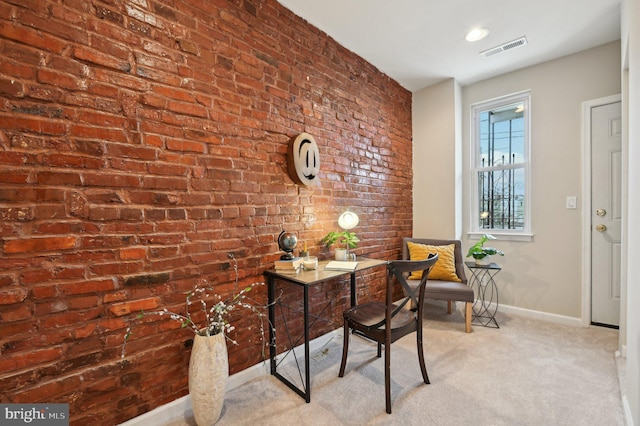 office area featuring light colored carpet and brick wall