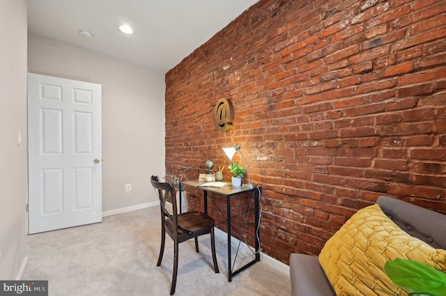 carpeted home office with brick wall