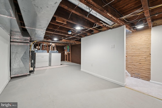 basement featuring heating unit and washing machine and clothes dryer