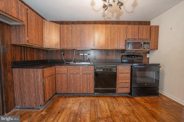 kitchen with black appliances, dark hardwood / wood-style flooring, and sink