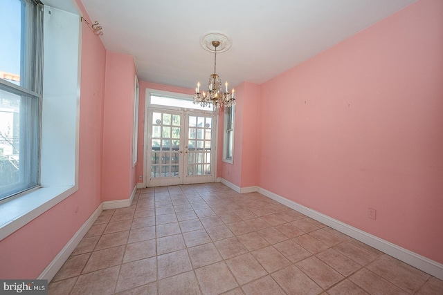 unfurnished dining area featuring french doors, light tile patterned floors, and a chandelier