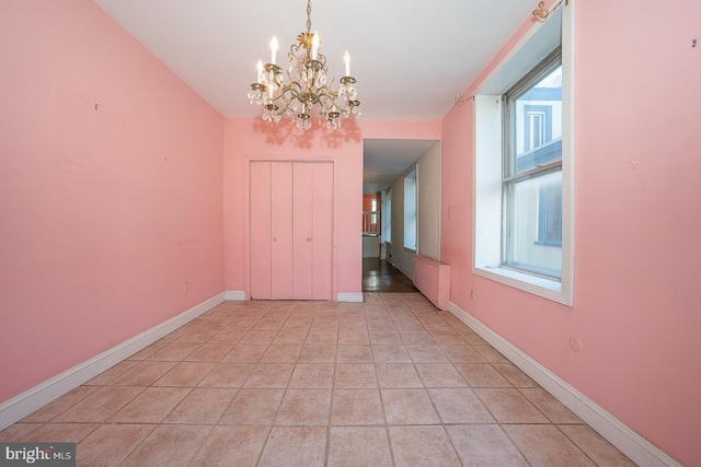 unfurnished dining area featuring a chandelier